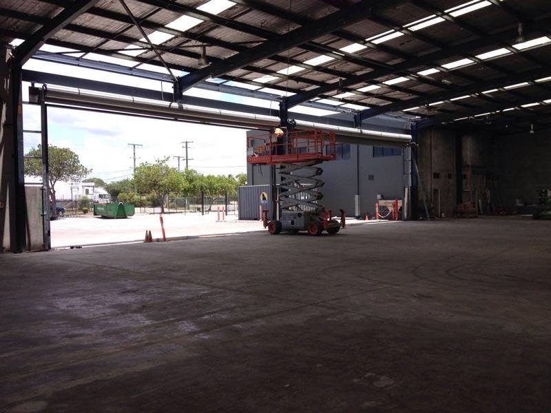Technician on a scissor lift servicing a large industrial door opening