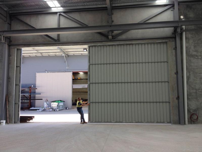 Large industrial sliding door being opened in a warehouse